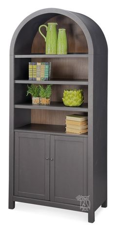 an arched bookcase with books and vases on top