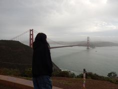 a person looking at the golden gate bridge