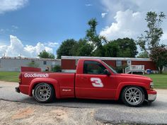 a red pick up truck parked in front of a fire station with the number 5 on it's side