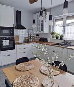 an image of a kitchen setting with flowers in vases on the dining room table