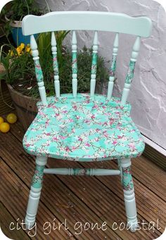 a wooden chair sitting on top of a wooden deck next to a potted plant