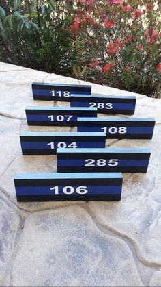 four blue numbered signs sitting on top of a cement slab