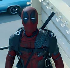 a deadpool character is standing in front of a wall with an arrow on it