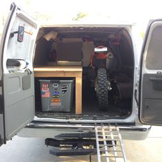 the back end of a van with its cargo compartment open and tools in the trunk