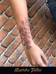 a woman's arm with flowers on it and the words, bushab tattoo