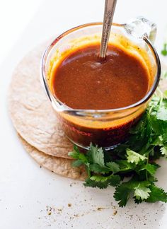 a small glass bowl filled with sauce and garnished with cilantro