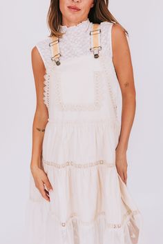 This dress is all about the details! The overall style is accented with lace trim and beautiful mesh and floral detailing. And don't forget the golden embroidery on the straps for a touch of glamour. Who says you can't have it all? Details Overall style Lace trim Mesh/floral detail Golden colored embroidery on straps Sizing Approximate measurements: SIZE LENGTH BUST Small 43" 36" Medium 44" 38" Large 46" 40" Fabric has no stretchModel is 5’8 wearing small Material 100% CottonHand wash coldHang t Elegant Summer Suspender Dress With Lace Trim, Elegant Lace Trim Suspender Dress For Summer, Elegant Lace Suspender Dress With Lace Trim, Sleeveless Suspender Dress With Lace Trim For Spring, Spring Sleeveless Suspender Dress With Lace Trim, Chic Cream Lace Dress With Lace Trim, Summer Cotton Lace Dress With Lace Trim, Spring Lace Dress With Spaghetti Straps And Lace Trim, Cream Spring Dress With Adjustable Straps