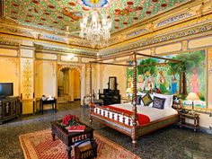 an ornately decorated bedroom with chandelier and paintings on the walls