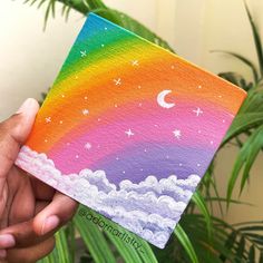 someone is holding up a card with an image of a rainbow in the sky and stars