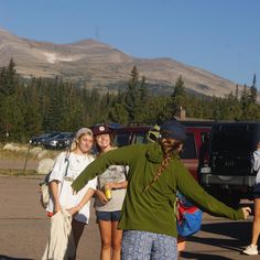 three girls standing in front of a truck with their arms out and one girl has her hand on the back of another woman's shoulder