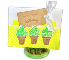 three ice cream cones with green icing on top and a card saying have a sweet birthday