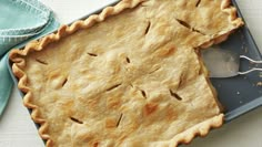 an uncooked pie sitting on top of a blue plate next to a spoon