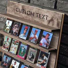 a display case with baseball cards on it in front of a brick wall that says custom text