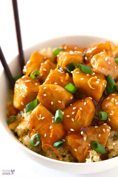 chicken with sesame seeds and green onions in a bowl