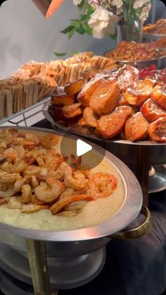 there are many different types of food on the buffet table, including breads and pastries