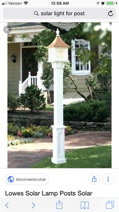 a white lamp post in front of a house