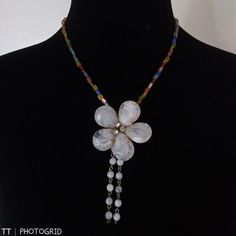 Brand New Handmade Multi Color Glass Beaded Necklace With Large Mother Of Pearl Color Flower Shaped Pendant With Drop Tassels Of Smaller Mother Of Pearl Beads And Silvertone Twist Clasp Approximate Measurements Are Taken With The Item Laying Flat And Are To Be Used As A Guide Only Please Let Me Know You Have Any Other Questions All Items In New Or Gently Used Condition Unless Otherwise Noted Offers Welcome Bundle And Save White Flower Charm Necklace For The Beach, White Flower Charm Necklace For Beach, White Necklace With Flower Charm For Party, White Beaded Flower Shaped Jewelry, White Beaded Flower Jewelry, White Party Necklace With Flower Charm, White Flower Decorated Necklaces For Party, White Flower Shaped Beaded Jewelry, White Flower-shaped Beaded Jewelry