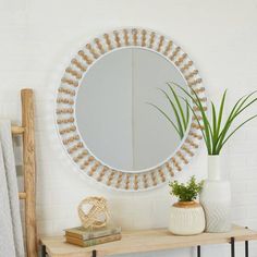 there is a mirror on the wall next to a shelf with plants and vases