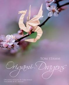 an origami dragon on a branch with flowers