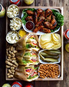 a tray filled with different types of food and snacks on top of a wooden table