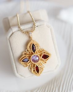 The beautiful pendant is made from an Amethyst as centre stone with 4 faceted Garnet cabochon in 14K gold filled wires. It simply hangs on a heavy gauge ball chain with lobster clasp and extension. Each piece of the Artisan Made collection is unique and only one is available. This lightweight and stylish necklace is the perfect way to add a touch of color and fashion to your wardrobe. It features luxurious gemstones that are durable, making it the perfect accessory for any occasion. The length o Wire Wrapped Yellow Gold Pendant Jewelry, Yellow Gold Wire Wrapped Pendant Jewelry, Wire Wrapped Flower Pendant Jewelry Gift, Handmade Amethyst Necklace In Yellow Gold, Gold Wire Wrapped Necklace With Oval Pendant, Gold Amethyst Wire Wrapped Jewelry, Gold Oval Pendant Necklace Wire Wrapped, Gold Wire Wrapped Oval Pendant Necklace, Gold Necklace With Wire Wrapped Oval Pendant