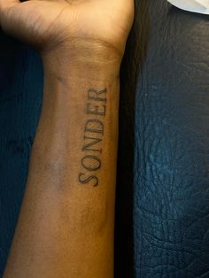 a person with a tattoo on their arm that says,'under so'in cursive writing