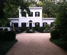 a large white house surrounded by trees and bushes