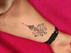 a woman's foot with a flower tattoo on her left ankle and the word love written in cursive writing