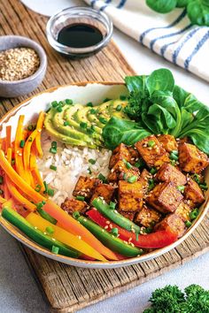 a bowl filled with rice, vegetables and tofu