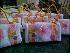 several bags with bows are lined up on the table, ready for someone to put them in