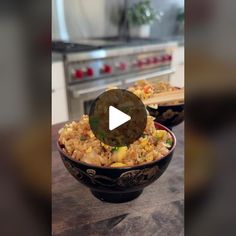 a bowl filled with rice and vegetables on top of a wooden table next to an oven