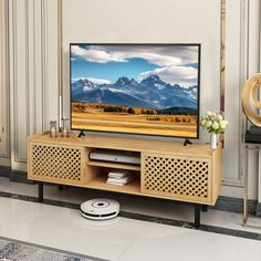 a flat screen tv sitting on top of a wooden entertainment center in a living room