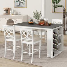 a dining table with four chairs and a wine rack in the middle, on top of a carpeted floor