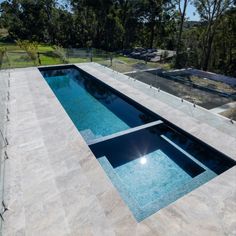 an above ground swimming pool with glass railings and trees in the backround