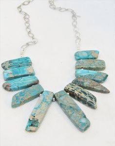 "These AGATE GRADUATED SPIKES are GORGEOUS! I LOVE the colors, the variations and the veining in these irregular stone pieces. The beaded section of the necklace is 6\" wide and the graduated stone varies from 1\" long to 1.5\" long. The length adjusts up to 22\" long and is secured with a lobster clasp. The spacers, findings, chain and clasp are pewter and silver plate. I think this stone is nothing short of breathtaking! The closeup pix dont even fully do it justice. It is amazing. This is a s Adjustable Jasper Jewelry In Turquoise, Adjustable Beaded Turquoise Agate Necklace, Adjustable Multicolor Jasper Necklaces, Adjustable Agate Necklace With Large Stone, Artisan Necklace With Large Adjustable Stone, Adjustable Rectangular Turquoise Necklace, Unique Adjustable Turquoise Necklace, Turquoise Rectangular Adjustable Necklace, Adjustable Agate Beaded Necklace With Stones