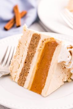 a piece of cake on a plate with a fork and cinnamon sticks in the background