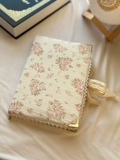 a book sitting on top of a table next to a vase with flowers and a candle