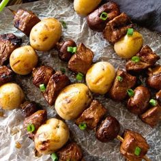 skewered meat and potatoes on a piece of wax paper