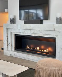 a living room with a fireplace and television mounted on the wall