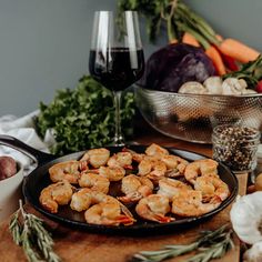 shrimp and vegetables on a table with wine