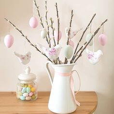 a vase filled with eggs and flowers on top of a table