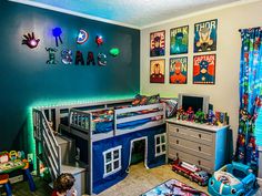 a child's bedroom decorated in blue and green with pictures on the wall above it