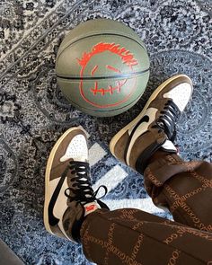 a person's feet are standing next to a basketball on the floor with their shoes up