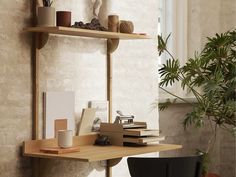 a wooden shelf with books and cups on it next to a potted plant in front of a window