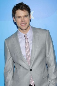 a man in a suit and tie smiling for the camera