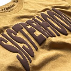 a yellow shirt with the word pittsburgh printed on it's chest and in brown lettering