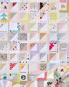 a close up view of a patchwork quilt with many different colors and designs on it