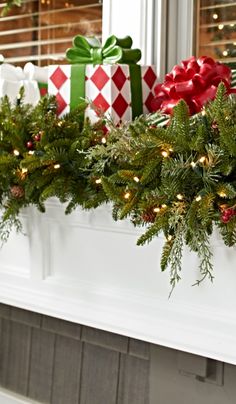 a christmas mantle with presents on it and lights in the window sill, along with other holiday decorations