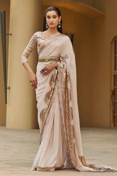 Whisper pink, gold silk georgette saree, featuring signature applique work and hand embellishments. Paired with an embellished blouse and a belt.
Component: 3
Applique, Embellished
Neckline: Scoop
Sleeve Length: Three Quarter
Fabric: Saree: Silk Georgette; Blouse: Dupion Silk
Color: Pink, Gold
Scallop cutwork saree hem
Scoop back neck with tassel tie-up
Adjustable buckle closure belt - Aza Fashions Gold Pre-draped Saree For Navratri Party, Elegant Pre-draped Saree With Gota Work, Gold Pre-draped Saree With Cutdana In Georgette, Elegant Embellished Blouse Piece For Navratri, Embellished Pre-draped Georgette Saree For Celebration, Gold Embellished Saree With Traditional Drape, Party Wear Embellished Pre-draped Saree For Celebration, Gold Pre-draped Saree For Wedding And Navratri, Gold Pre-draped Saree With Resham Embroidery In Georgette