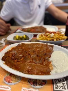 a man sitting at a table with plates of food